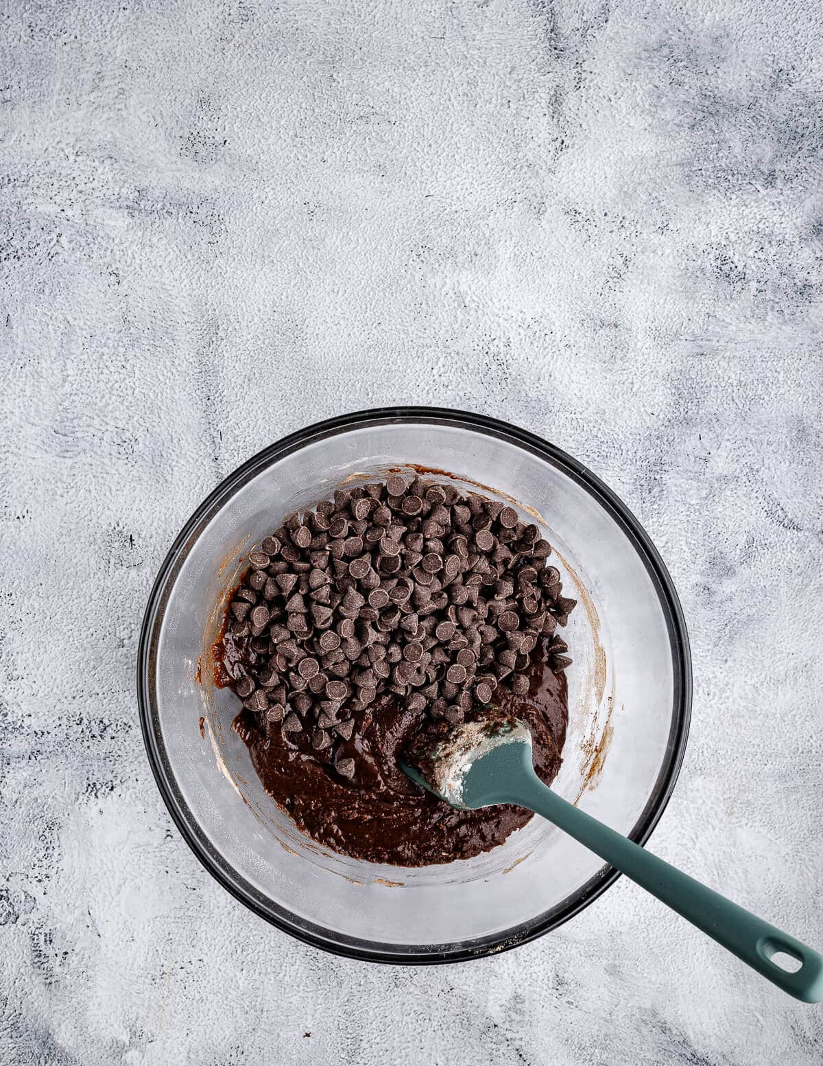 a bowl of chocolate cookie dough with chocolate chips on top.
