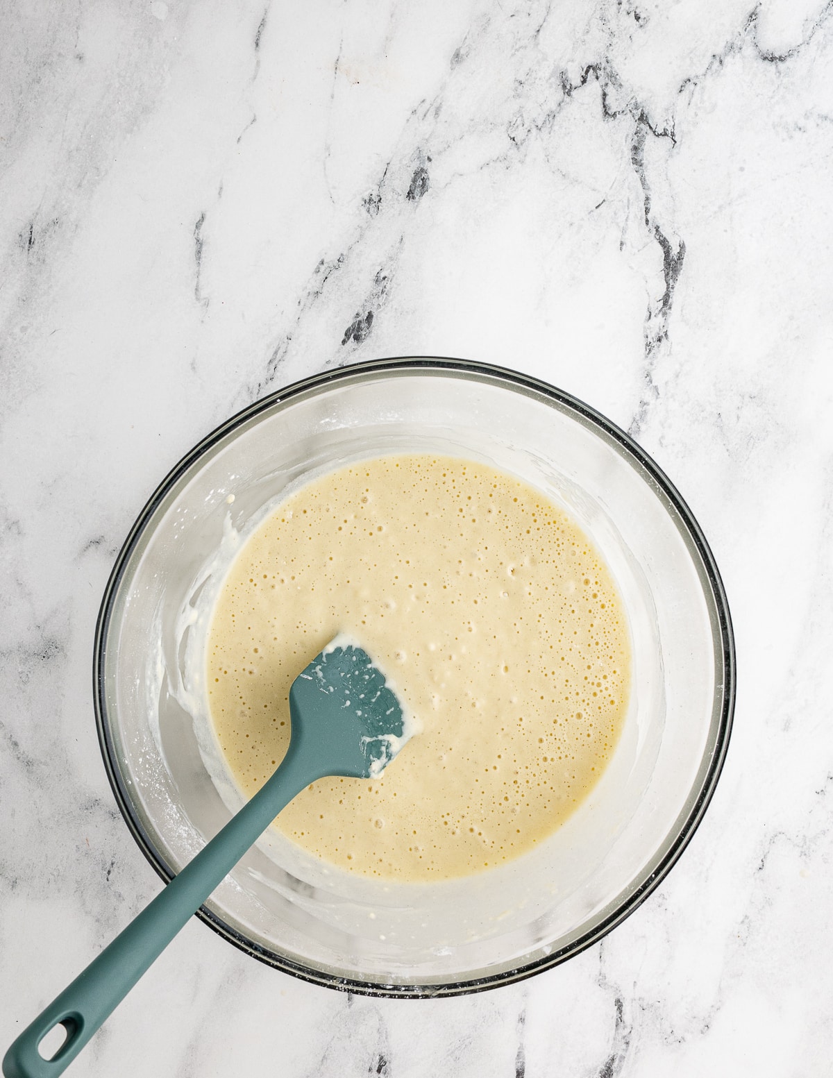 a bowl of gluten free waffle batter with a spatula in it.