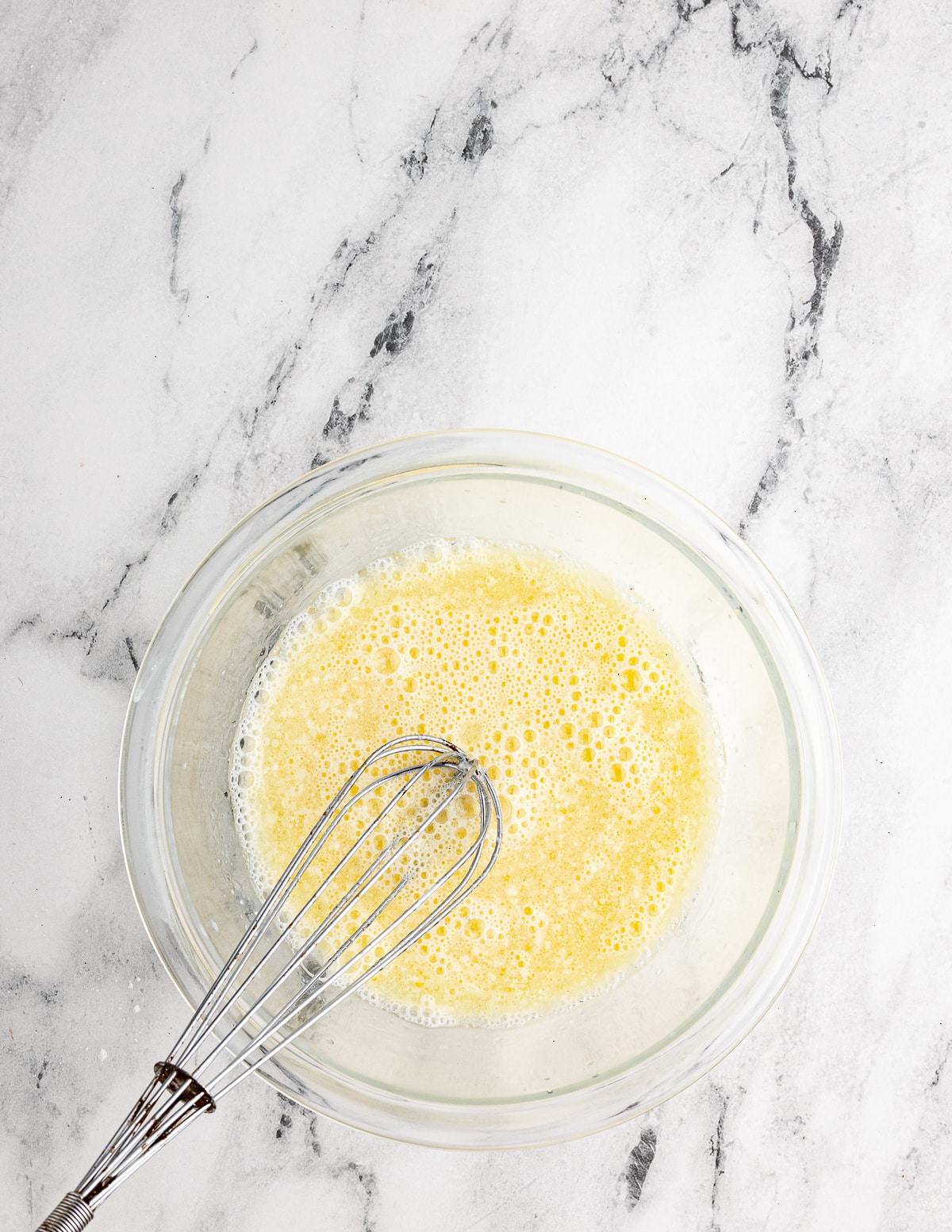 a bowl of eggs, oil, buttermilk, and milk mixed together.