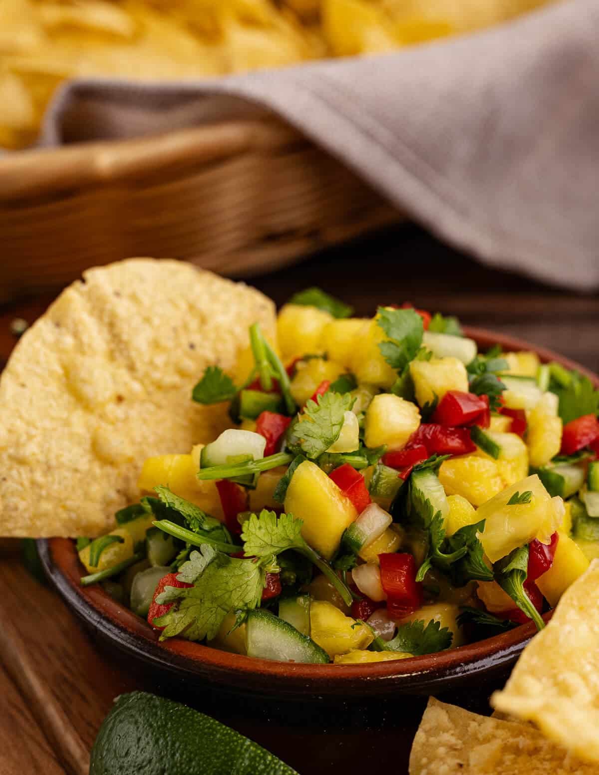 a bowl of salsa with a chip in it.
