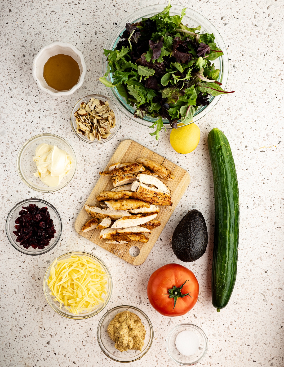 mixed greens, honey, sliced almonds, mayonnaise, lemon, cucumber, tomatoes, mustard, avocado, dried cranberries, and grilled sliced chicken.