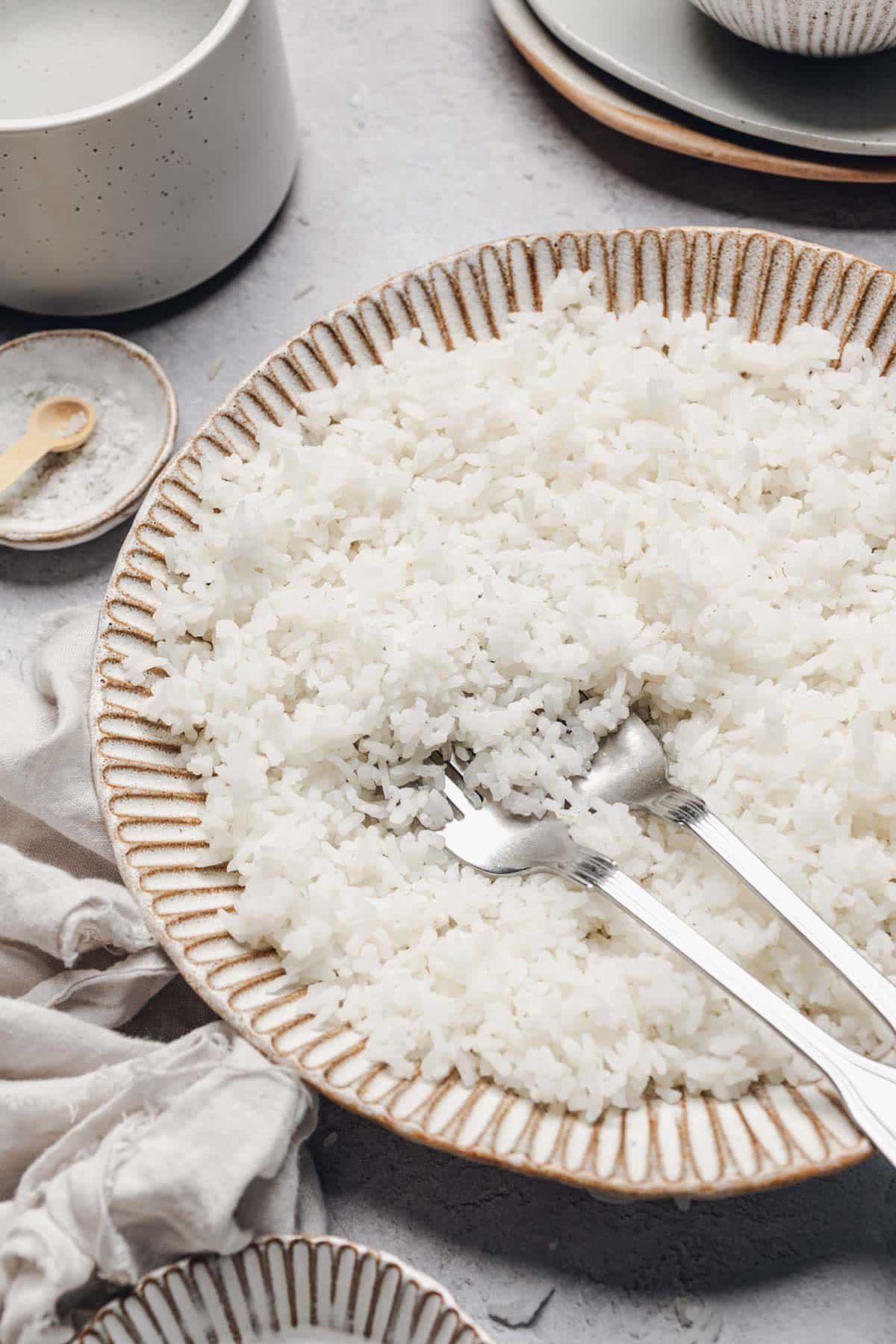 a bowl of white rice with two forks in it.