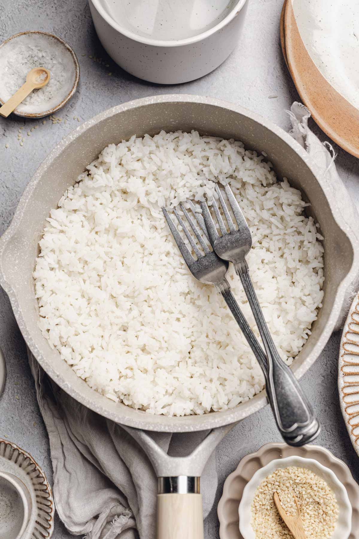 saucepan with cooked white rice in it and two forks.