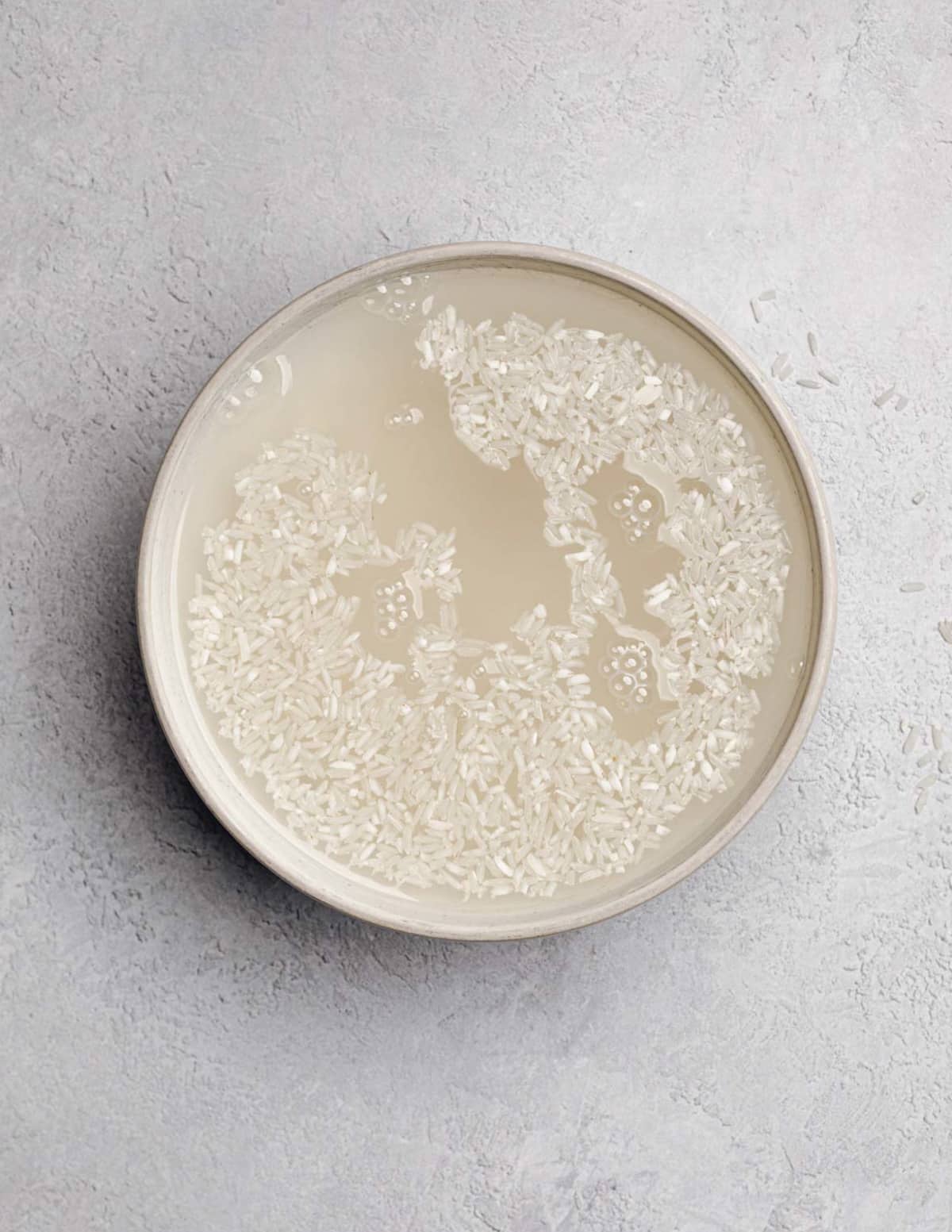 a bowl of white rice soaked in water.