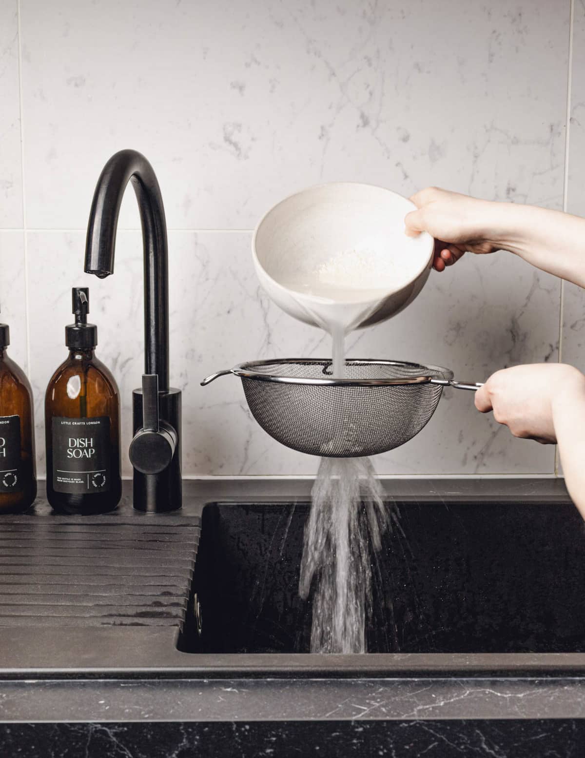 pouring the water and rice into a handheld strainer.