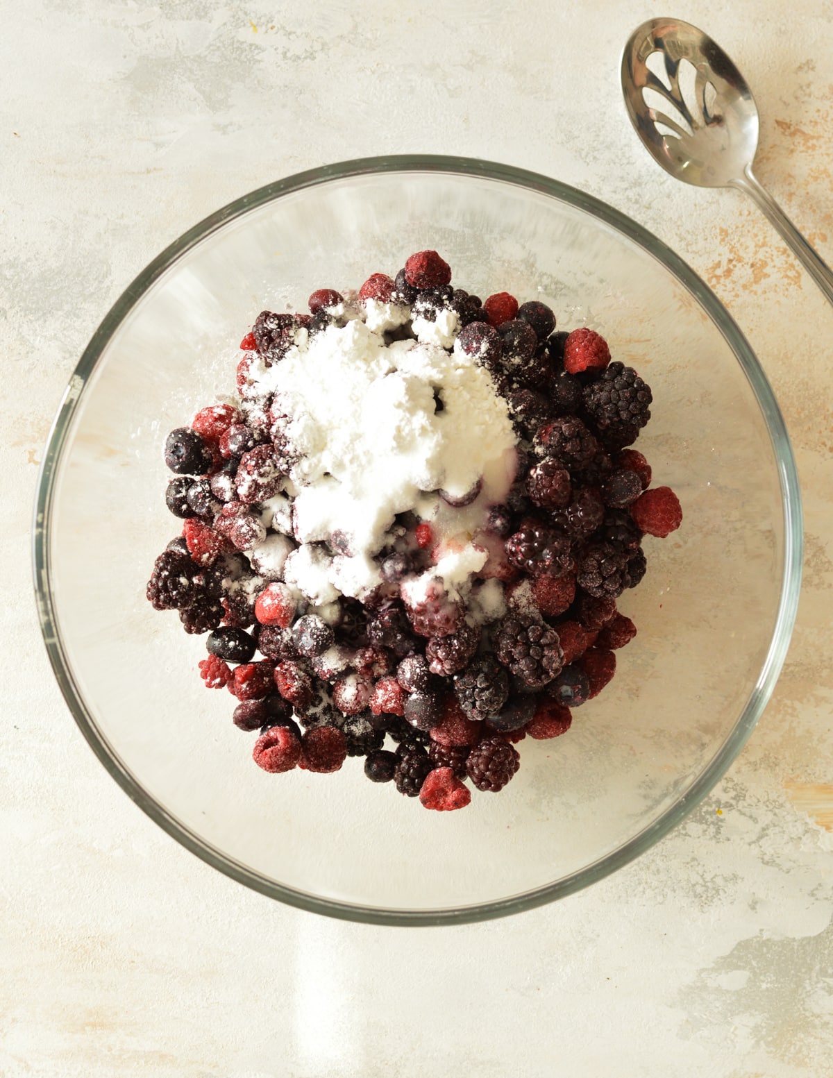 a bowl of mixed berries with cornstarch on top