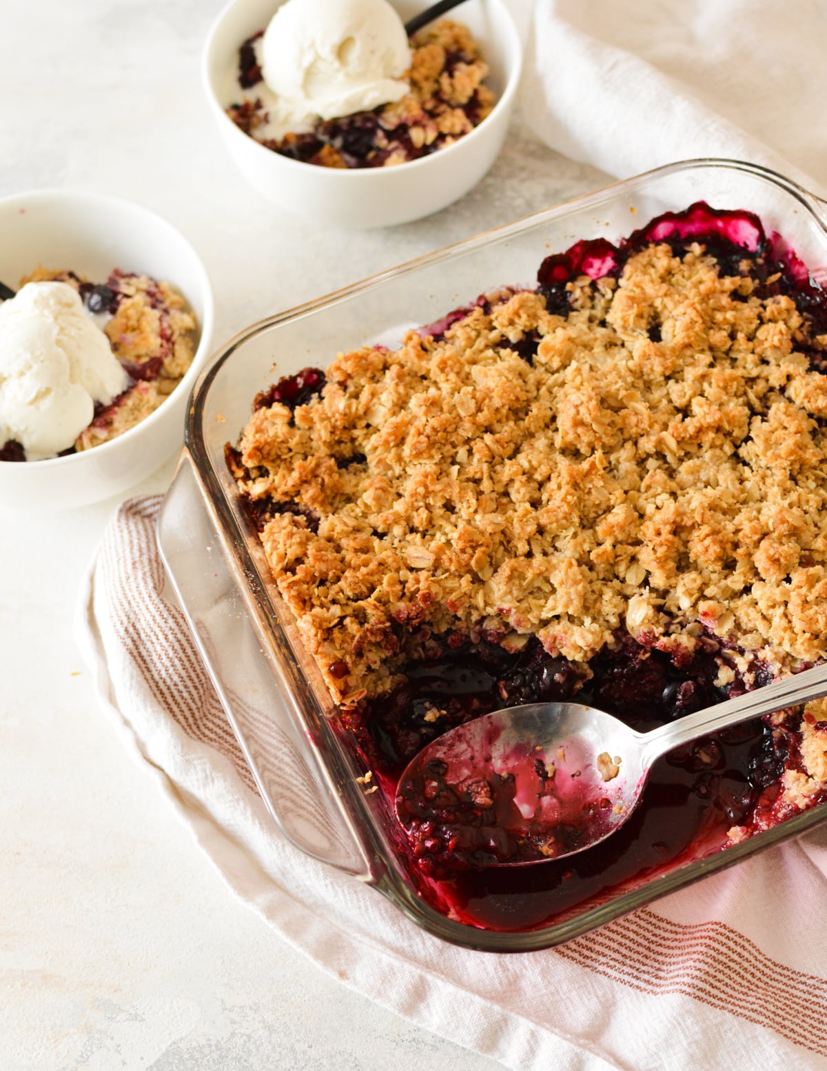 a triple berry crisp with a spoon in it