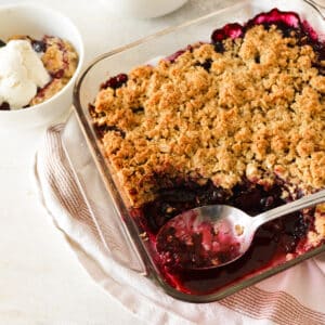 a triple berry crisp with a spoon in it