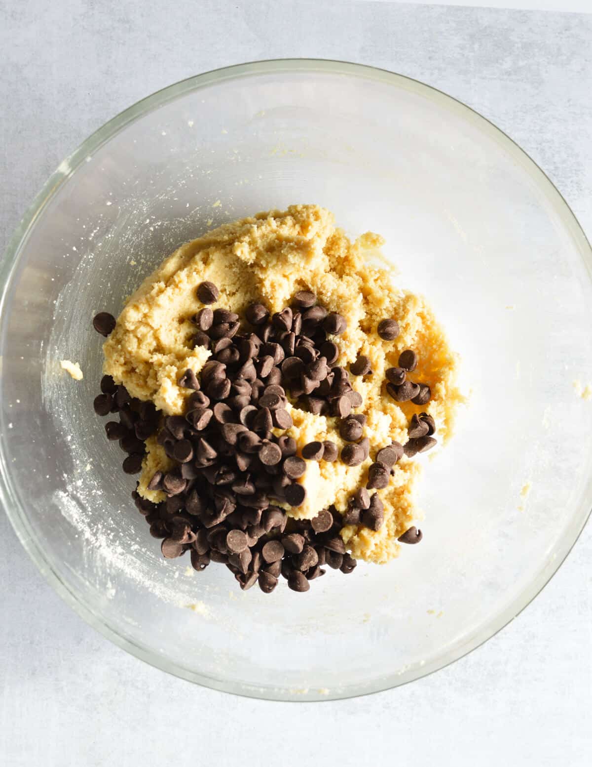a bowl of almond flour cookie dough with chocolate chips on top.