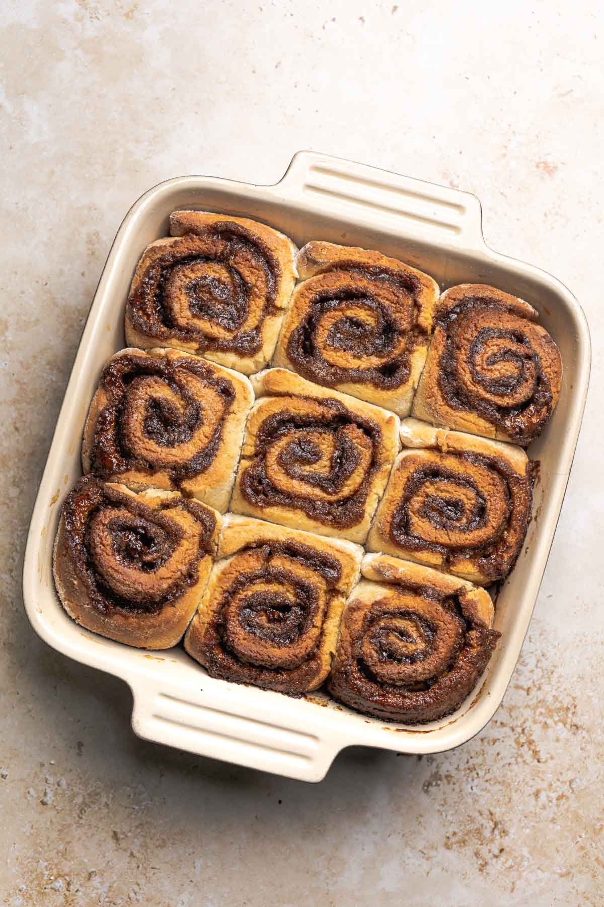 baked gluten free cinnamon rolls in a baking dish.