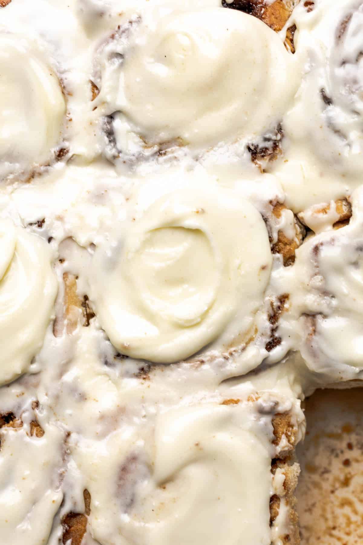 close up of cream cheese iced cinnamon rolls.