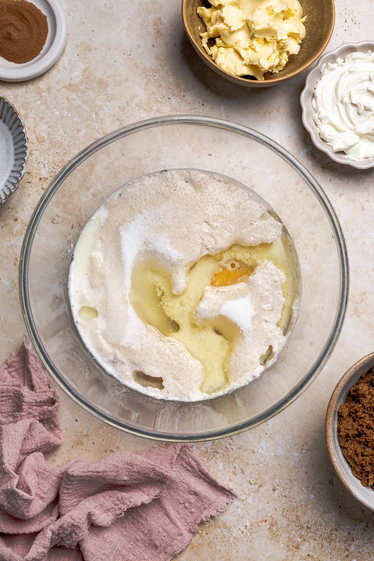 milk, yeast, eggs, sugar, and oil in a bowl.