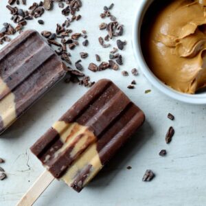 banana chocolate popsicles next to some peanut butter