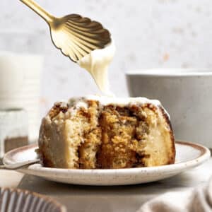 drizzling cream cheese frosting onto a cinnamon roll.