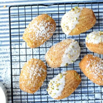 gluten free madeleines on a cooling rack next to icing