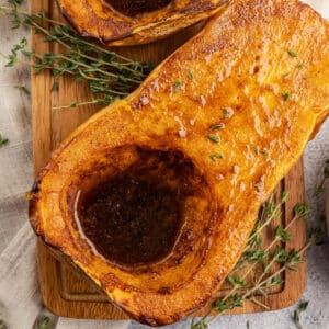 roasted butternut squash half with brown sugar and butter in it.