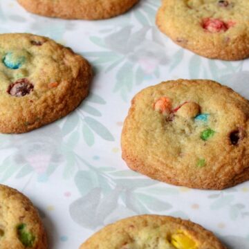 Gluten free m&m cookies laying flat on parchment paper