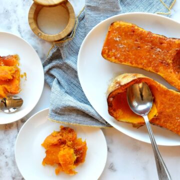 Two roasted butternut squash halves on a platter