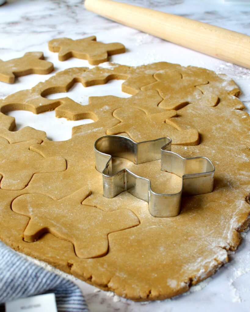 Gingerbread dough getting cut into gingerbread men