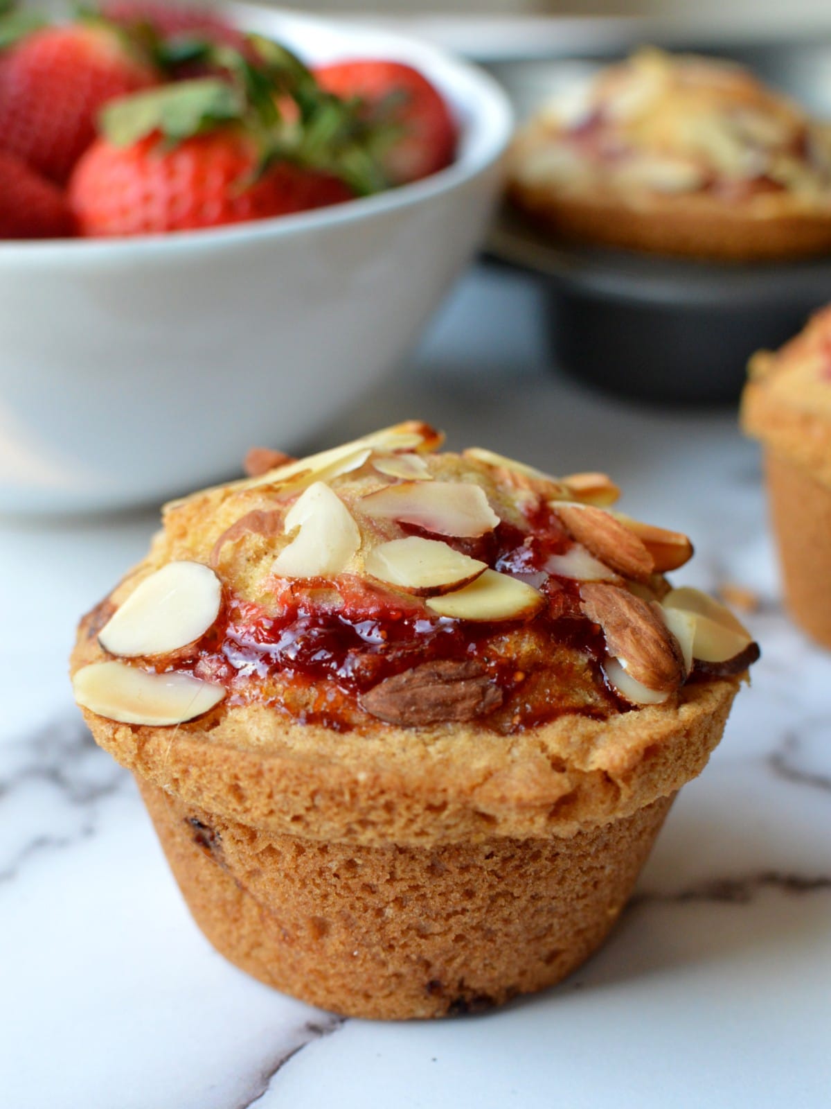 Luscious Gluten-Free Strawberry Muffins 5 A strawberry muffin with sliced almonds on top