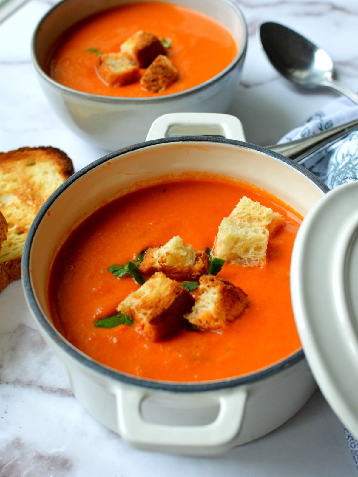 A bowl of tomato soup with croutons