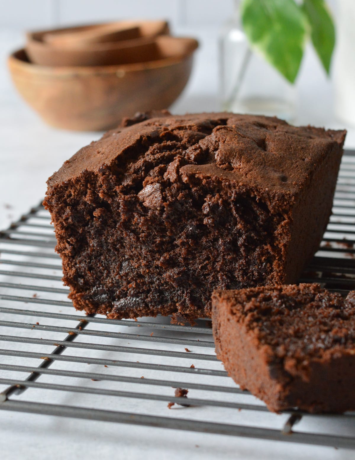 half of a gluten free chocolate pound cake on a wire rack.