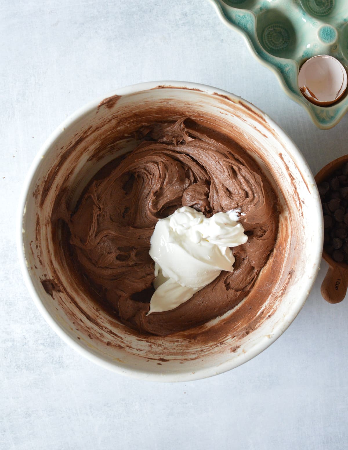 a bowl of gluten free chocolate batter with sour cream on top.