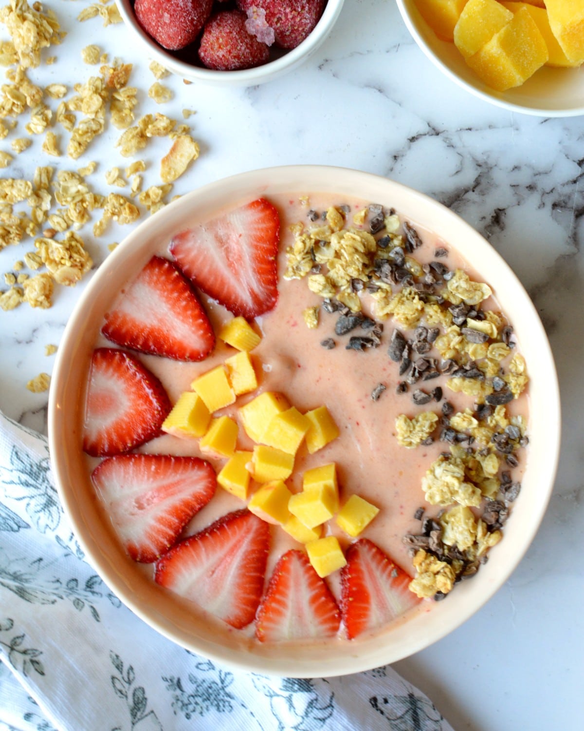 strawberry mango smoothie bowl with toppings.