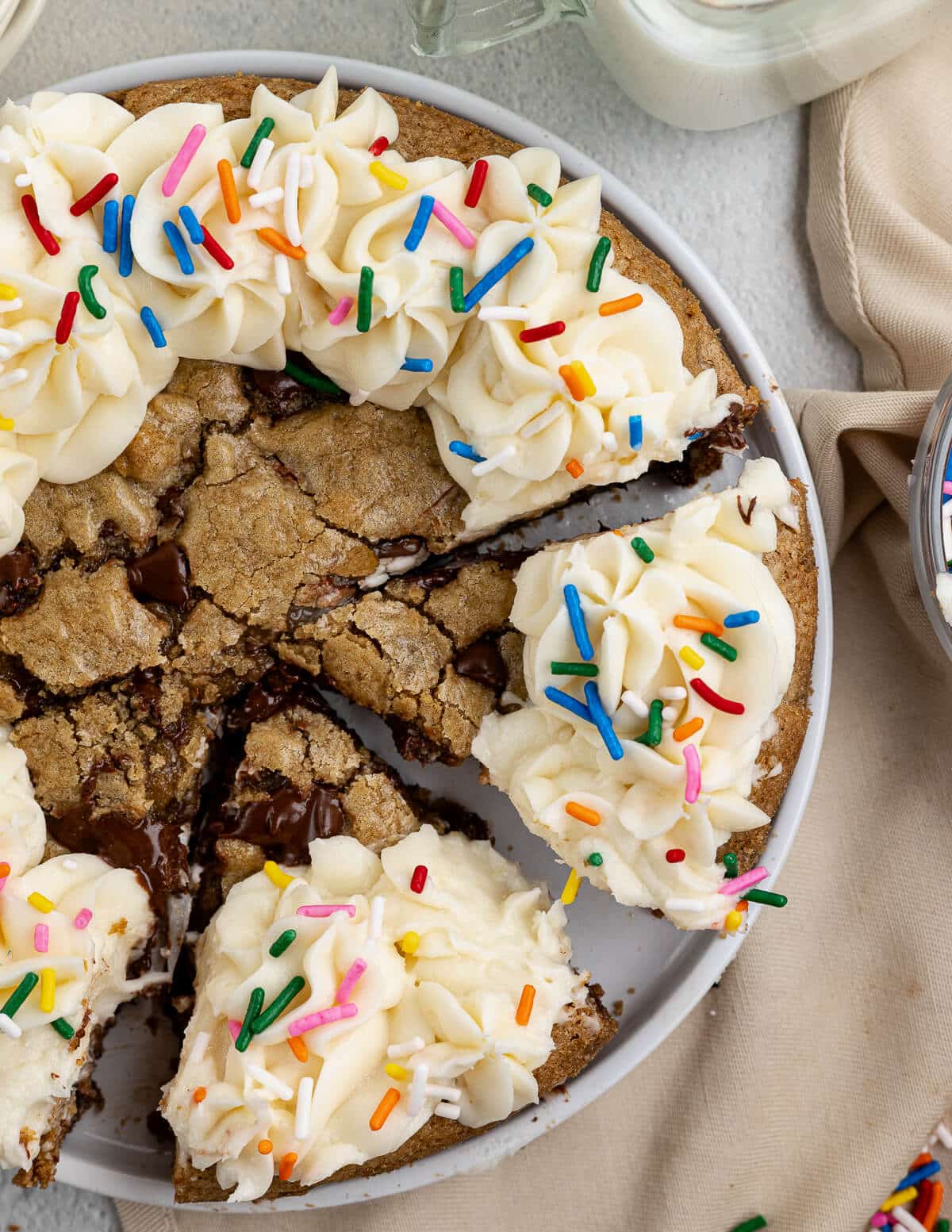 slices of gluten free cookie cake with buttercream and sprinkles on top.