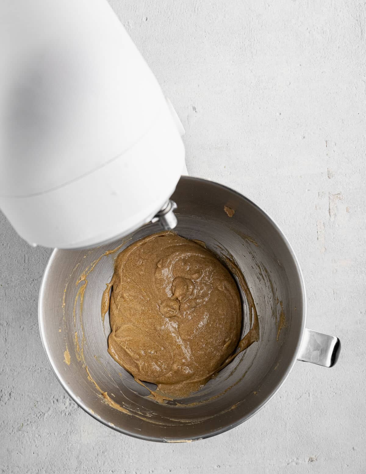 butter, sugar, and egg mixed together in the bowl of a stand mixer.