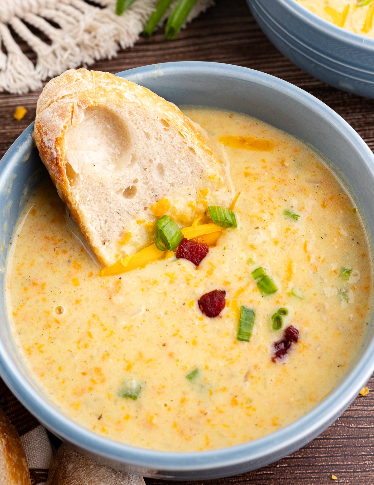 a bowl of potato soup with a slice of bread in it.