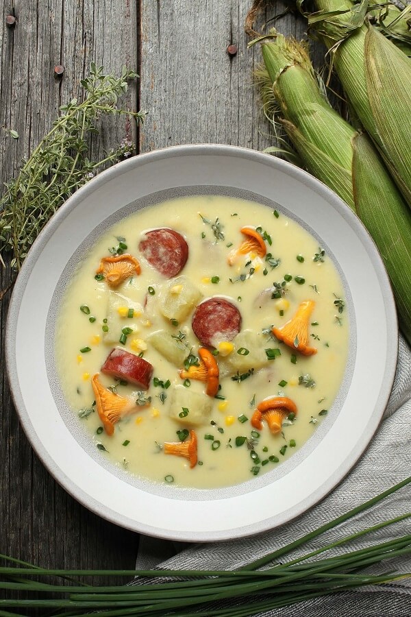 a bowl of corn chowder with sausage and mushrooms