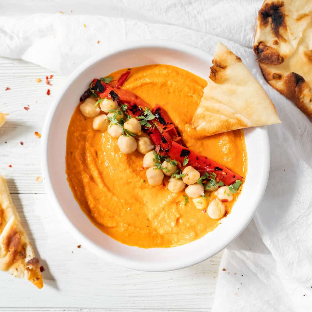 a bowl of roasted red pepper hummus