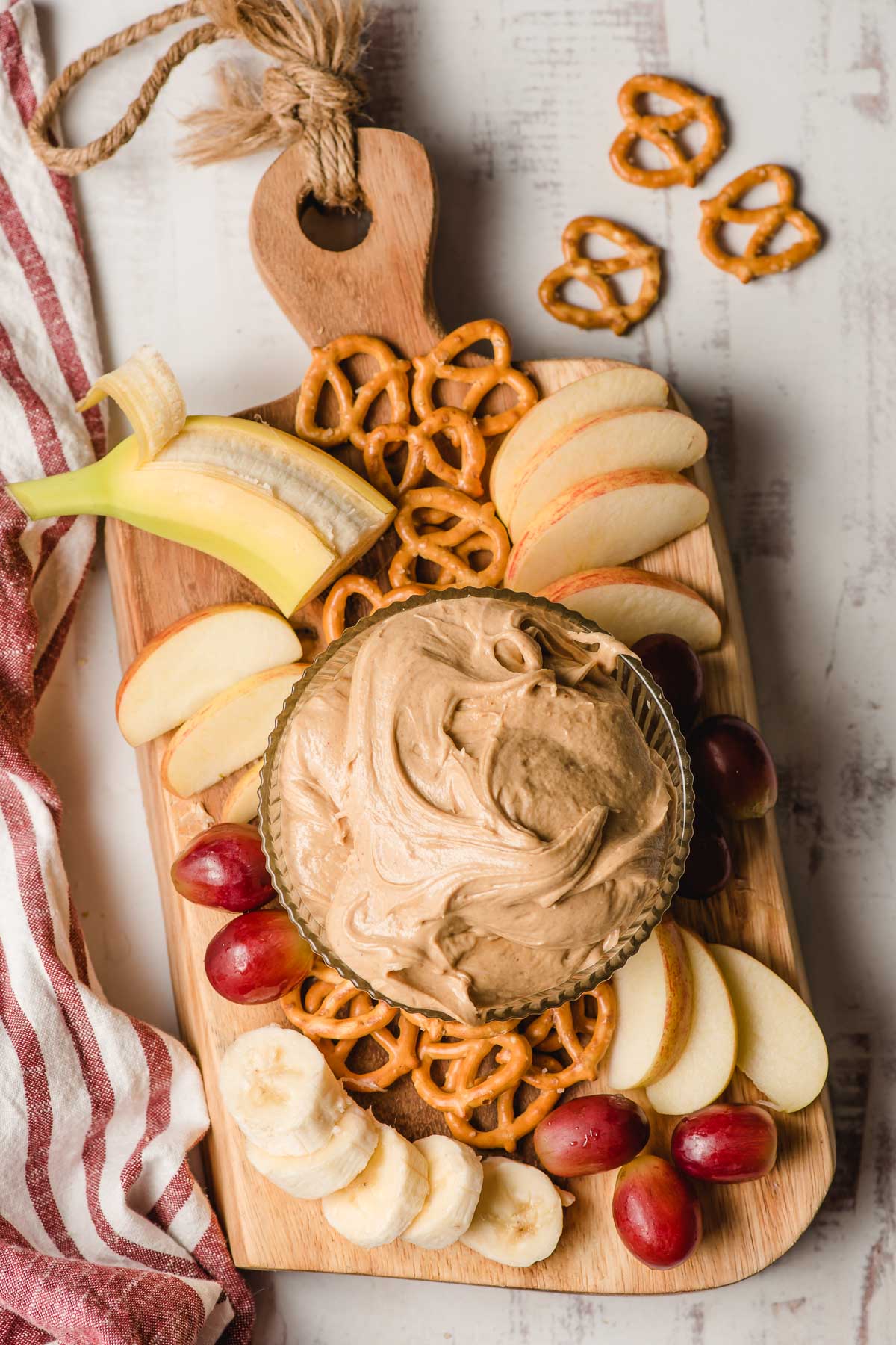 peanut butter dip next to apples and pretzels