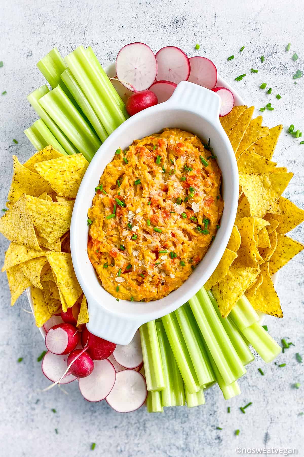 a ramekin of vegan buffalo dip and tortilla chips