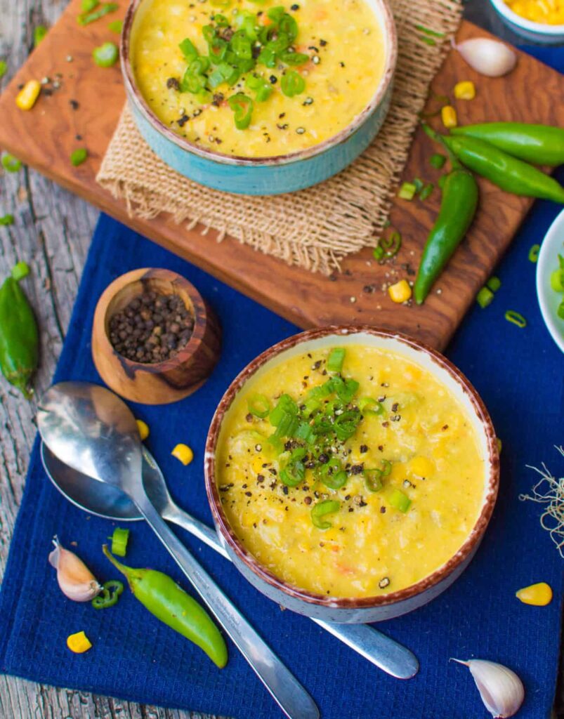 a bowl of corn chowder with green onions