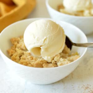 a bowl of apple crisp with vanilla ice cream