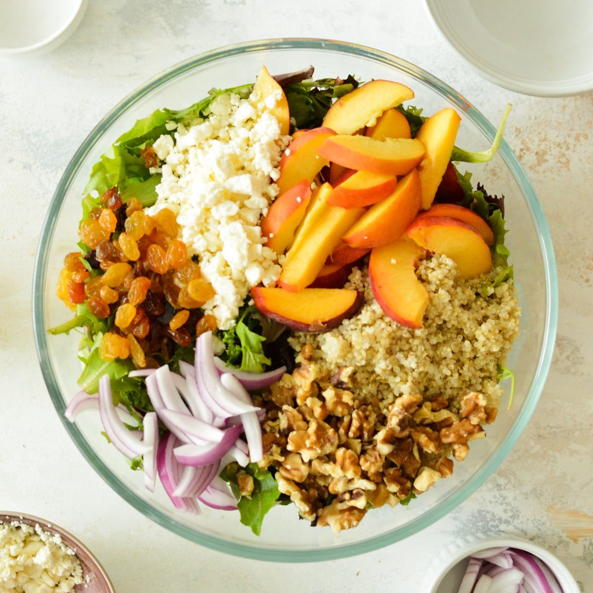 feta, peaches, raisins, quinoa, red onions, and mixed greens