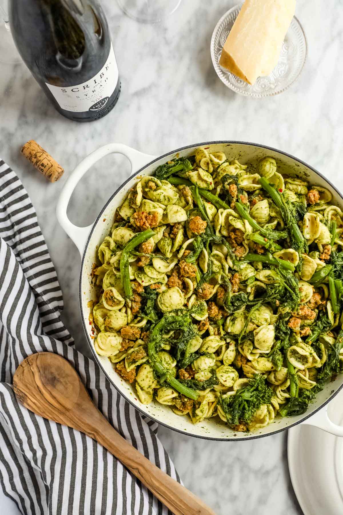 a dutch oven with pesto pasta and sausage