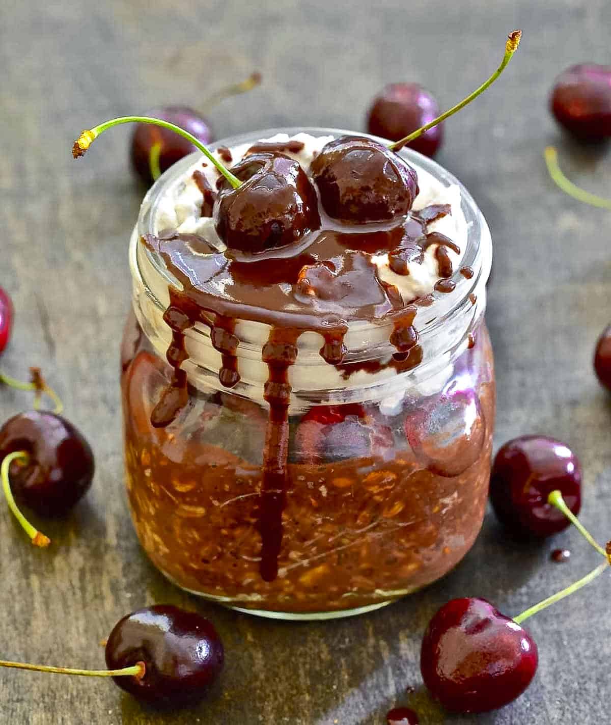 a jar of overnight oats with chocolate and cherries