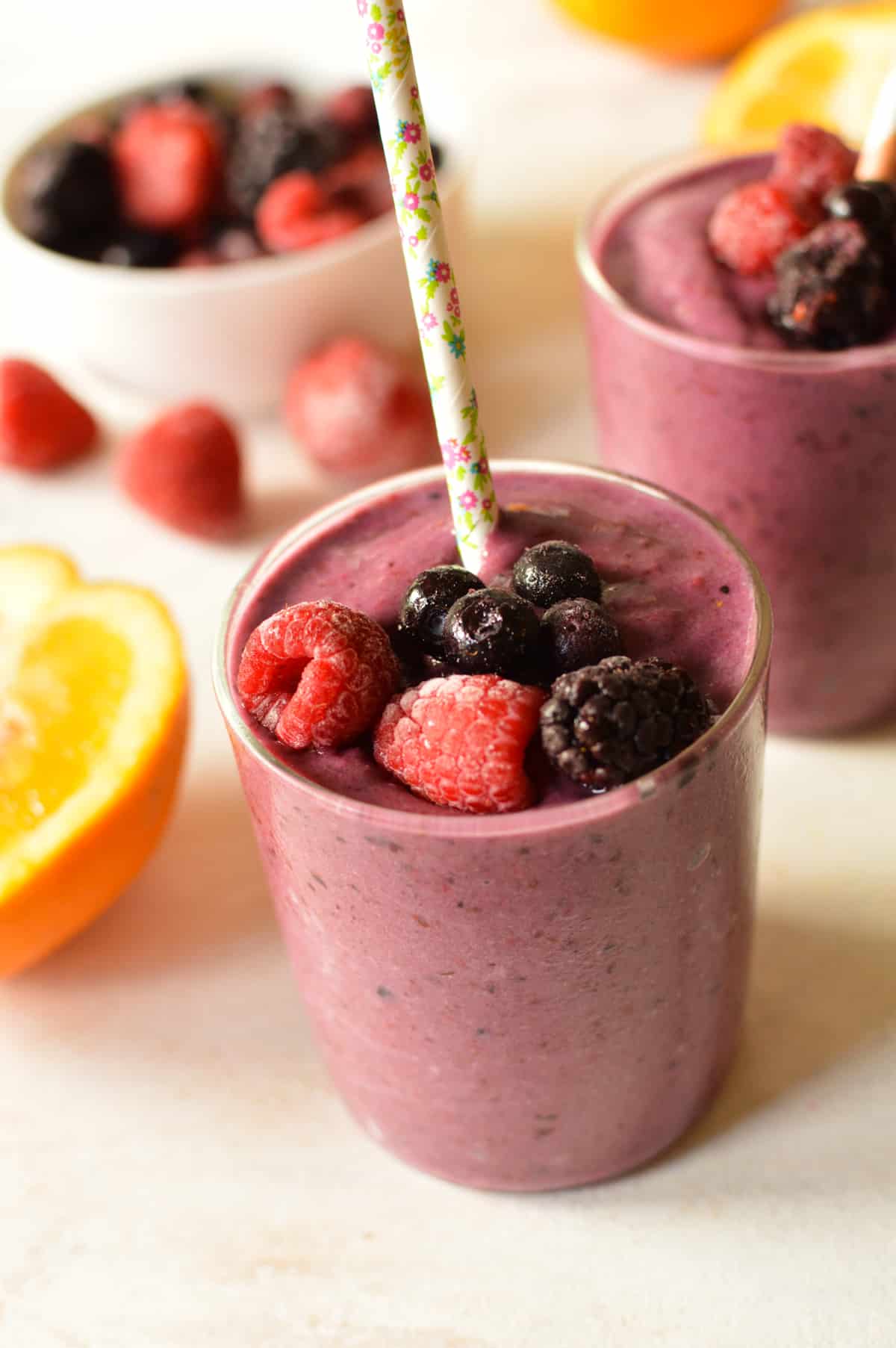 a glass of berry smoothie with berries on top