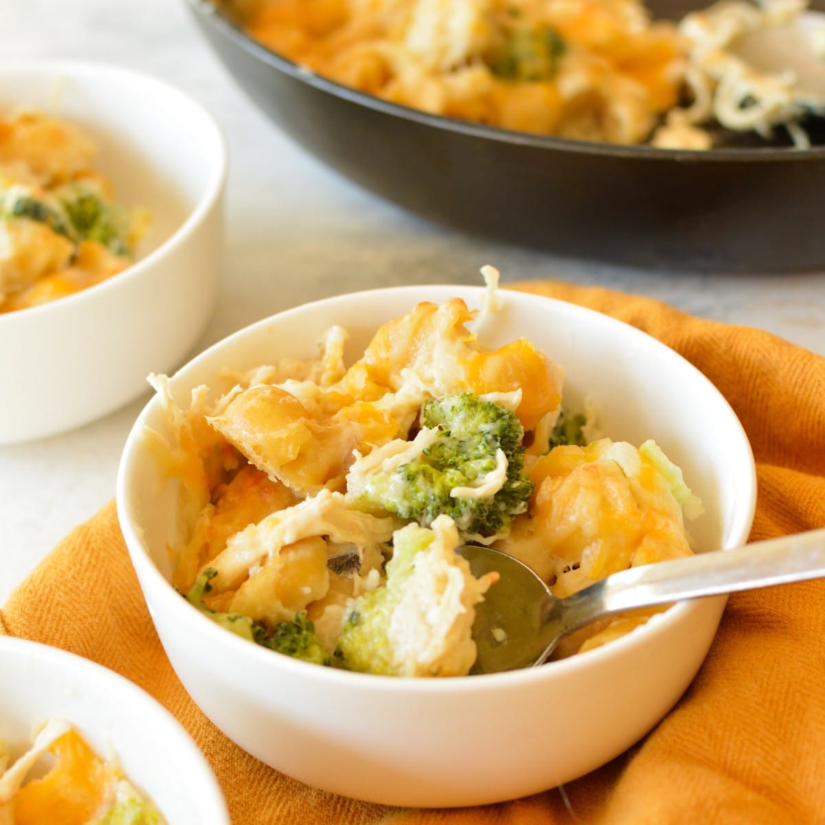 a bowl of chicken and broccoli pasta with cheese