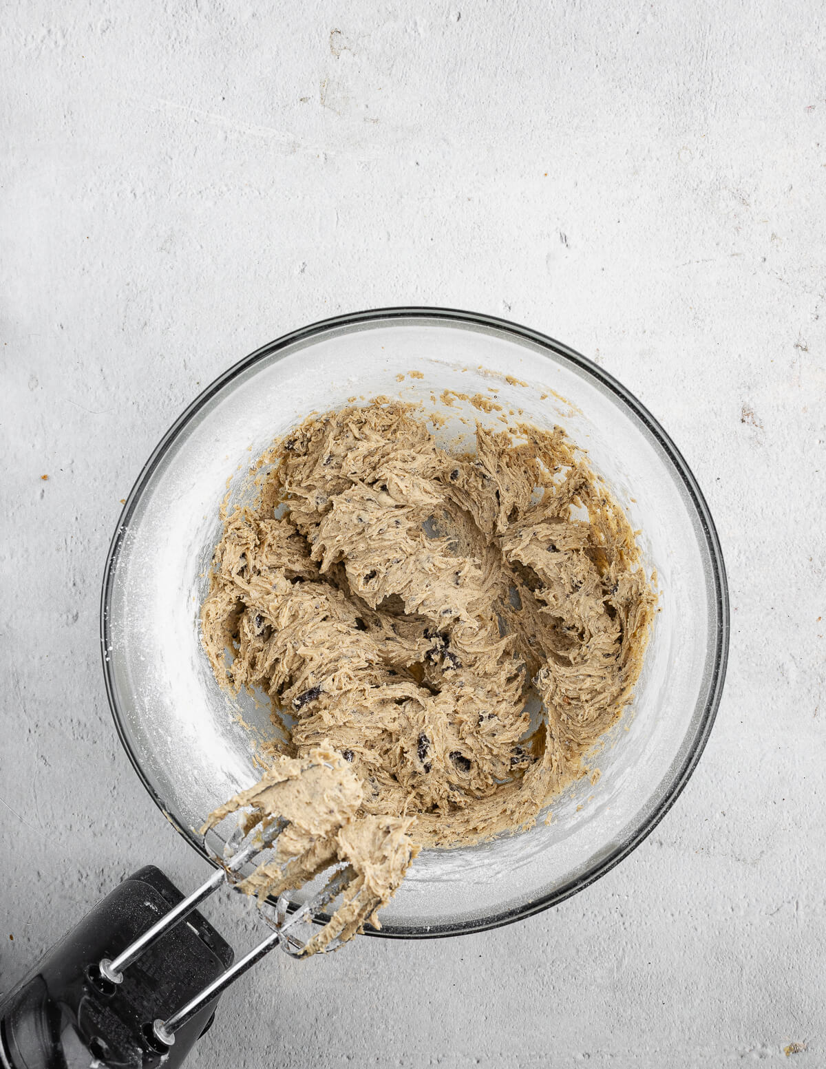 a bowl of cookie dough with cookie crumbs in it.
