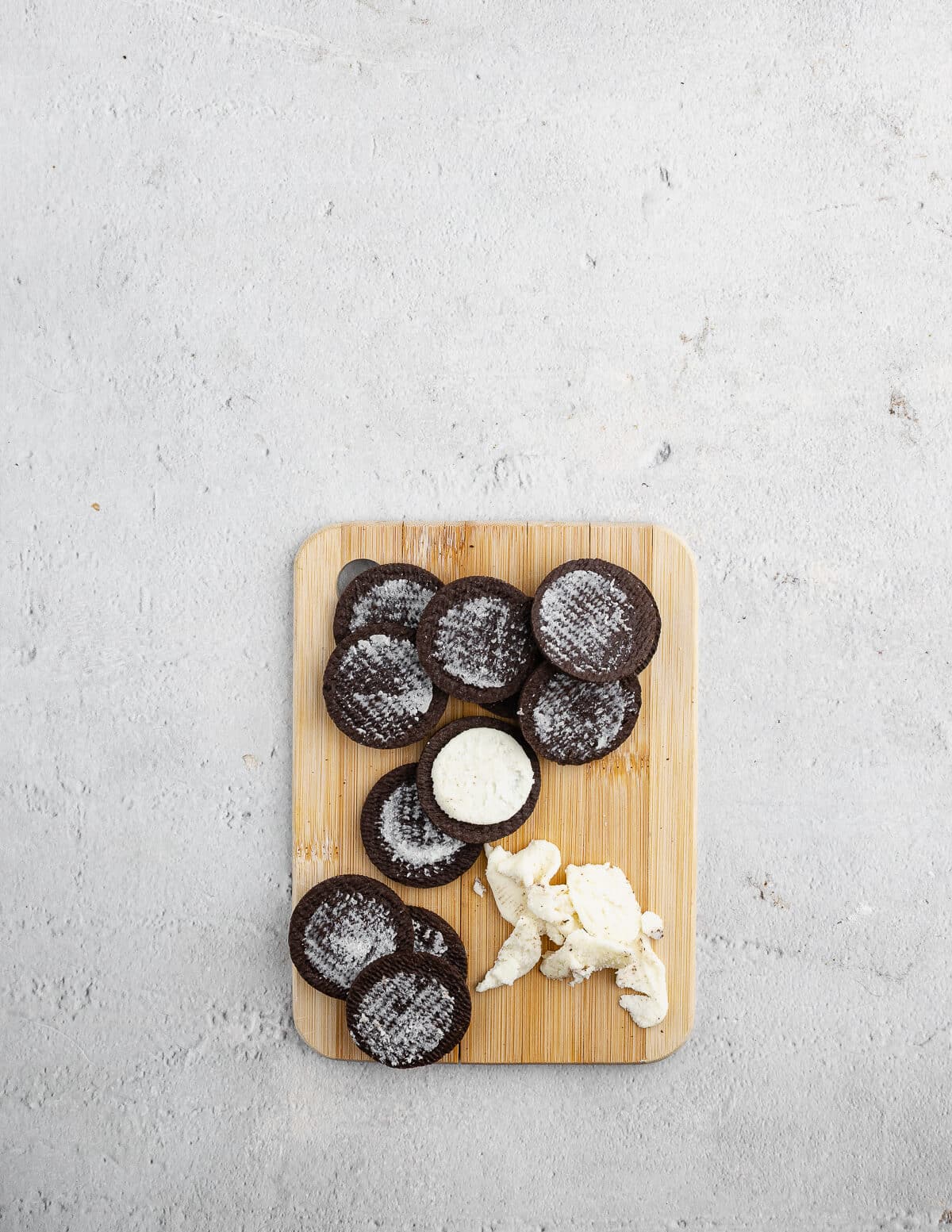Oreo cookies on a cutting board with the filling removed from them.