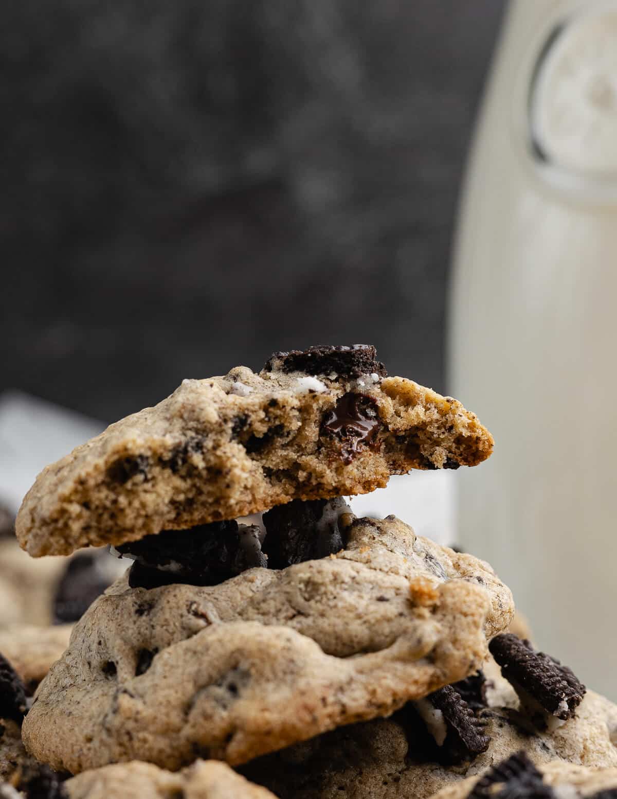 a stack of cookies and cream cookies with a bite out of it.