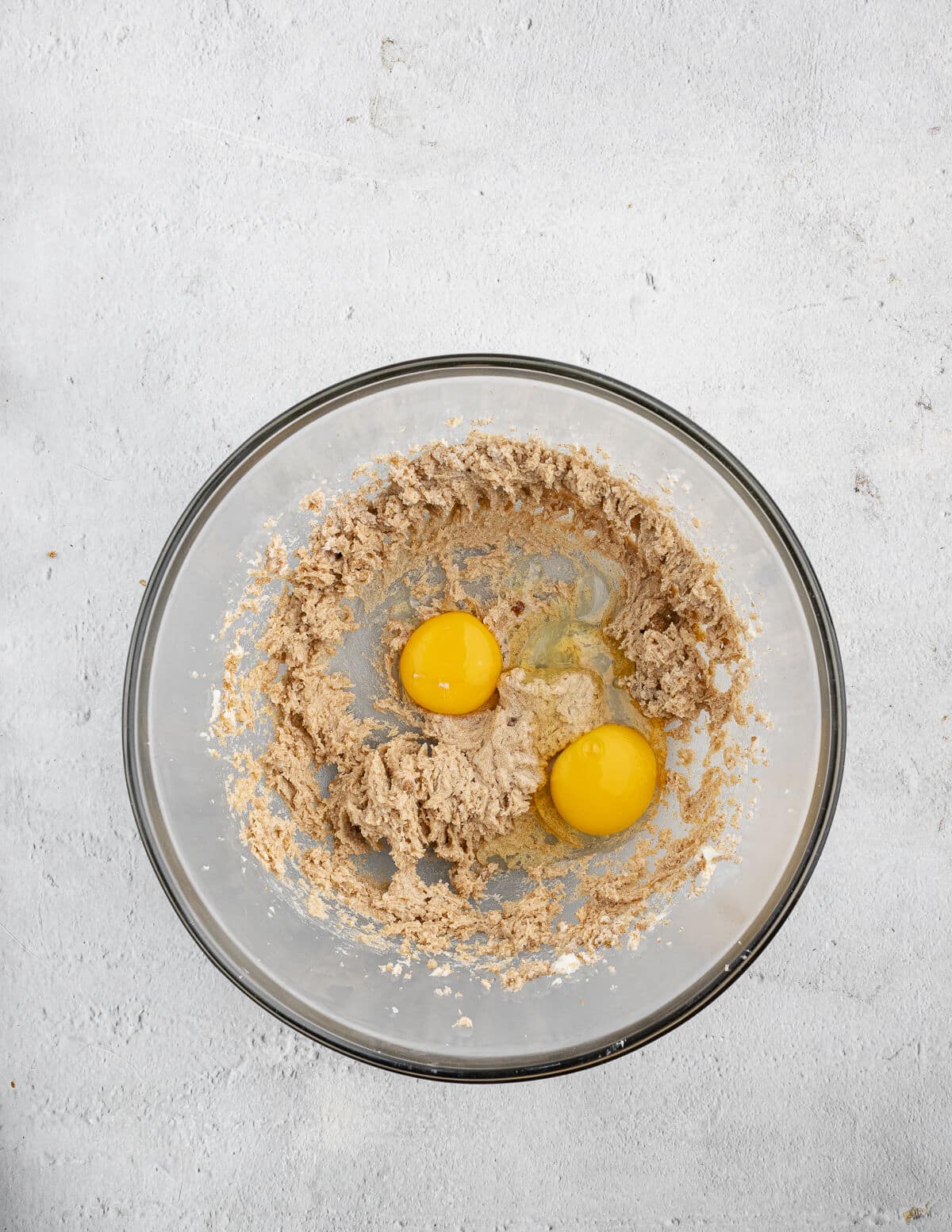 creamed butter and sugar in a bowl with eggs on top.