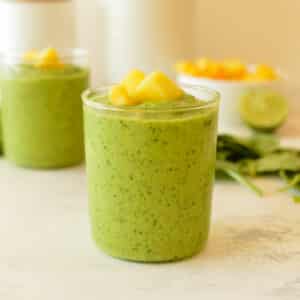 a green smoothie with mango on top