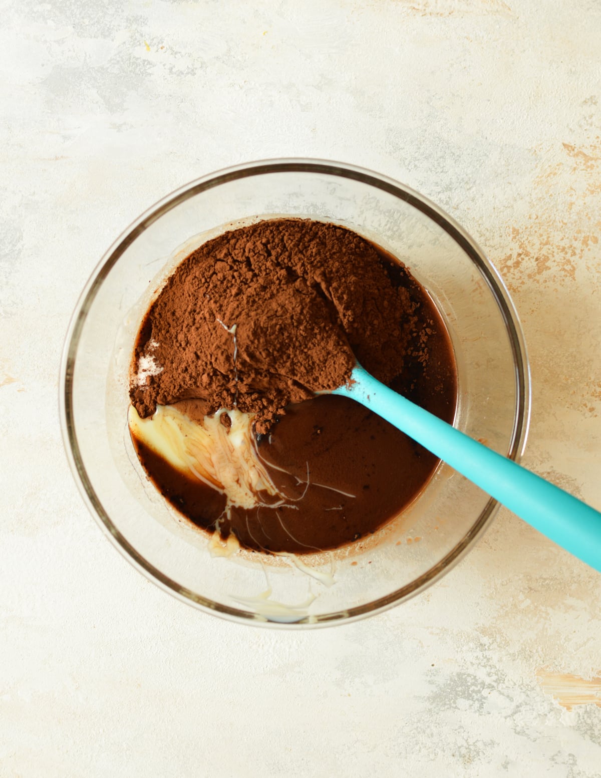 a bowl of melted chocolate with cocoa powder and sweetened condensed milk