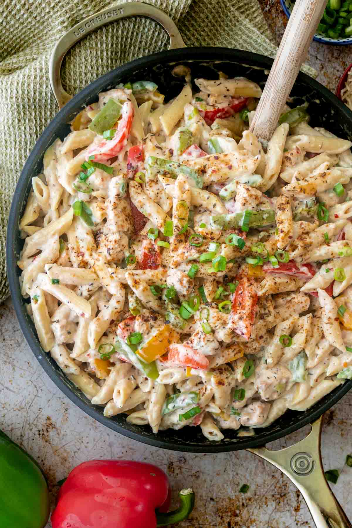 a skillet with pasta, chicken and bell peppers.