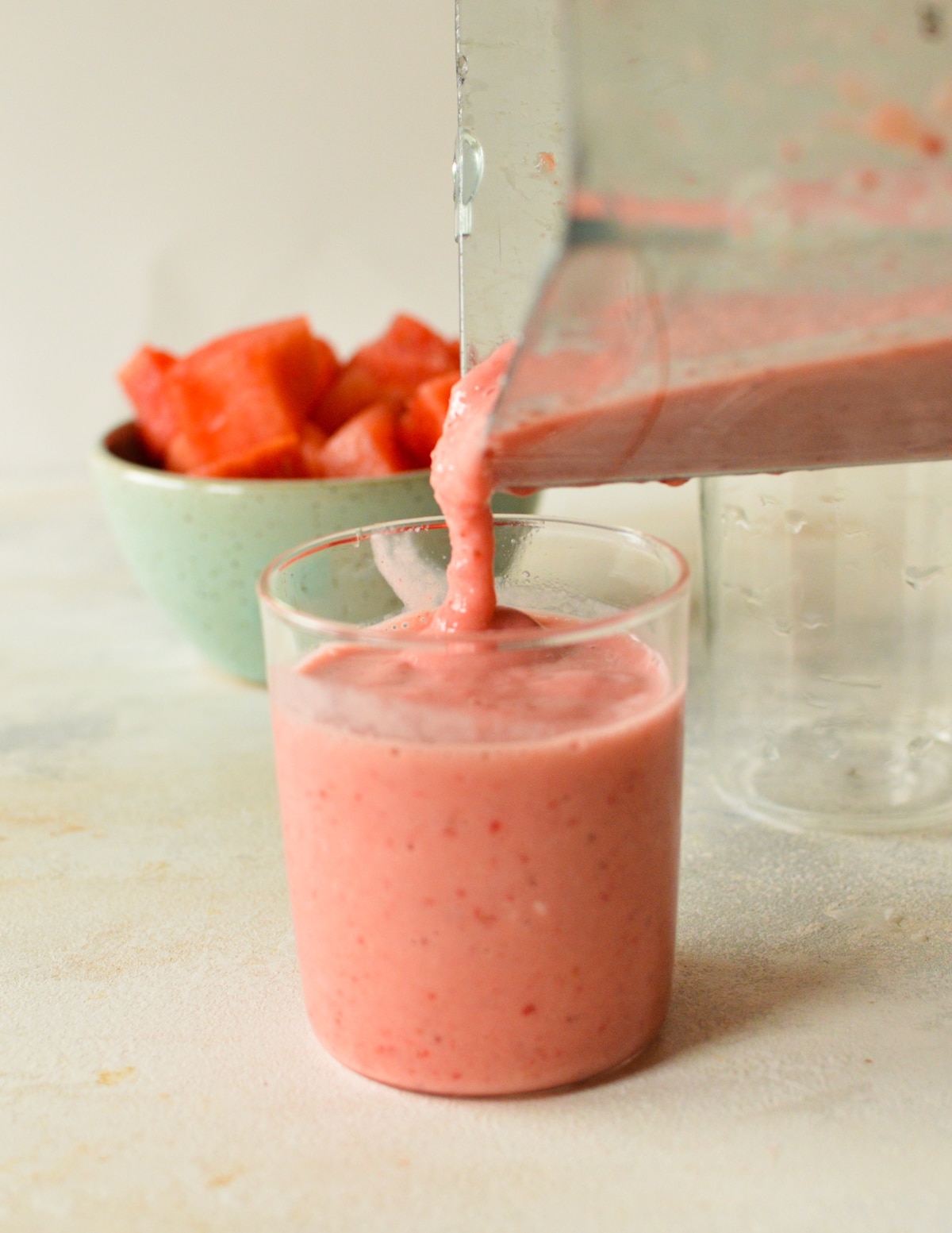 pouring smoothie into glass.